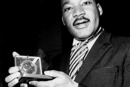 Dr. Martin Luther King, Jr. displays his 1964 Nobel Peace Prize medal in Oslo, Norway, December 10, 1964.  The 35-year-old Dr. King was honored for promoting the principle of non-violence in the civil rights movement.  (AP Photo)