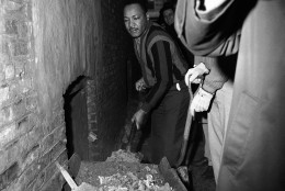 Martin Luther King attacks slum conditions at an apartment building in Chicago, Illinois on Feb. 23, 1966. Al Raby, CCO, and King and several Catholic priests use shovels to clean up wheelbarrows of trash and ashes from the basement from stair steps. (AP Photo/Edward Kitch)
