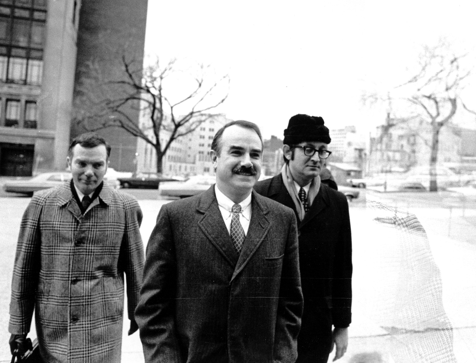 Three of the seven defendents, including G. Gordon Liddy, center, charged in connection with the break-in and alleged bugging of Democratic headquarters arrive at U.S. District Court for the start of their trial on Jan. 8, 1973. Others are unidentified. (AP Photo)