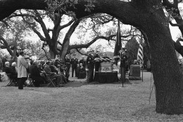 Rev. Billy Graham delivers the eulogy at the funeral of former President Lyndon B. Johnson at the family cemetery on the LBJ ranch in Stonewall, Texas on Jan. 25, 1973. The family is seated at the left with Mrs. Lady Bird Johnson sitting in the center of the group. (AP Photo)