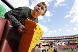Brandon Lowery hangs over the edge of the stadium seating to watch for the Green Bay Packers arrival before an NFL wild card playoff football game against the Washington Redskins in Landover, Md., Sunday, Jan. 10, 2016. (AP Photo/Mark Tenally)
