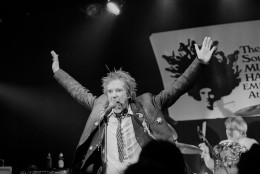 Johnny Rotten, leader of the English punk band the Sex Pistols gestures during their debut in the United States, in Atlanta, Ga., Jan. 6, 1978. Memphis, Tenn., is the next stop for the band. In the background is drummer Paul Cook. (AP Photo/Joe Holloway Jr.)