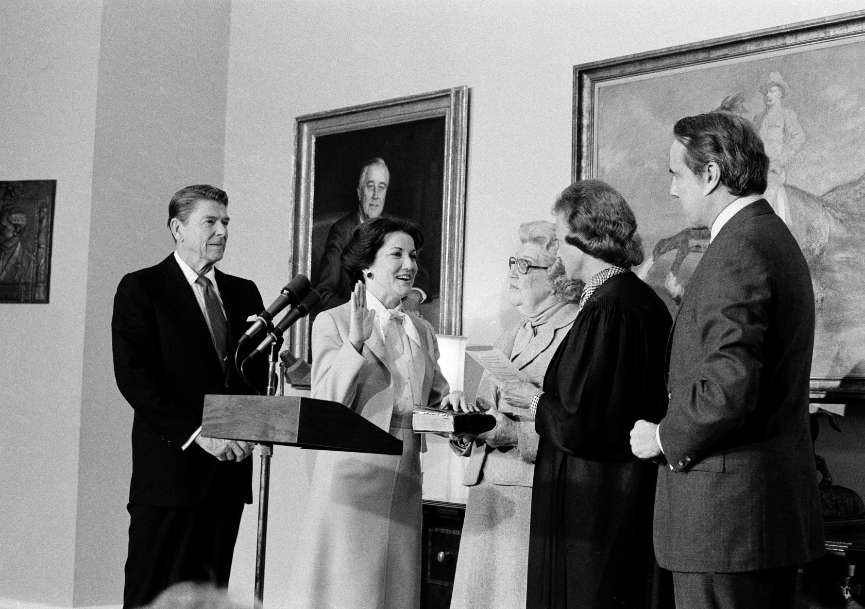 Supreme Court Justice Sandra Day O'Connor swears in Elizabeth Dole as the new Transportation Secretary, as President Reagan looks on at left, in an East Room ceremony at the White House, Feb. 7, 1983.  At far right is the husband of the secretary, Sen. Robert Dole, R-Kan., and at center is her mother, Mary Hanford.  (AP Photo)