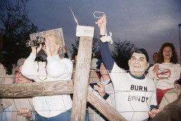 A toy bunny is hung in effigy by Jerry Jackson of Atlanta Ga., wearing a Ronald Reagan mask, and the pro-death penalty crowd rejoices after the Theodore Bundy execution, Jan. 25, 1989 at sunrise in Starke, Fla. (AP Photo/Mark Foley)