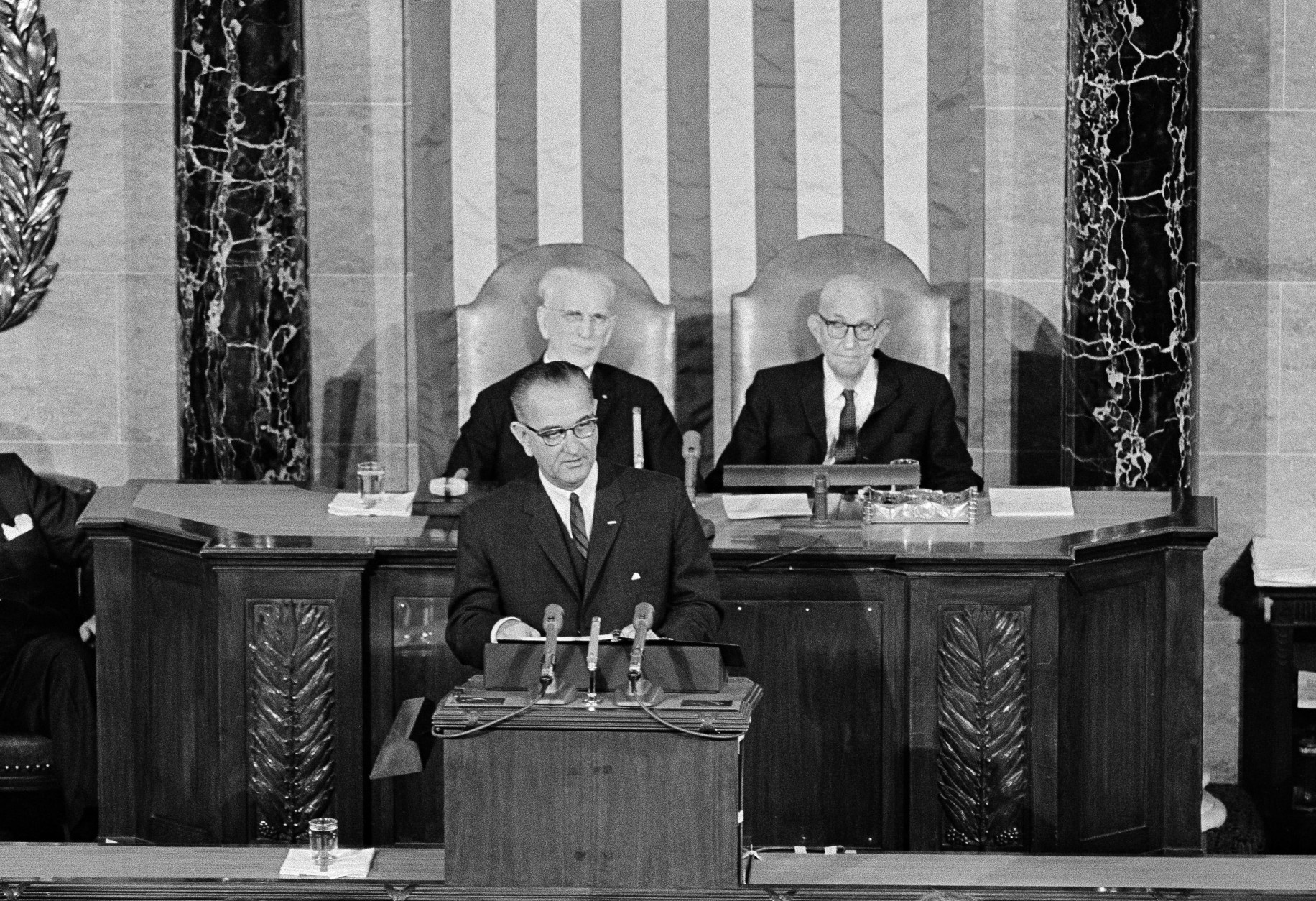President Lyndon B. Johnson delivers his State of the Union address to a joint session of Congress in the House of Representatives, Jan. 8, 1964. In background are Speaker John McCormack and Sen. Carl Hayden, right, Senate president pro temp.  (AP Photo)