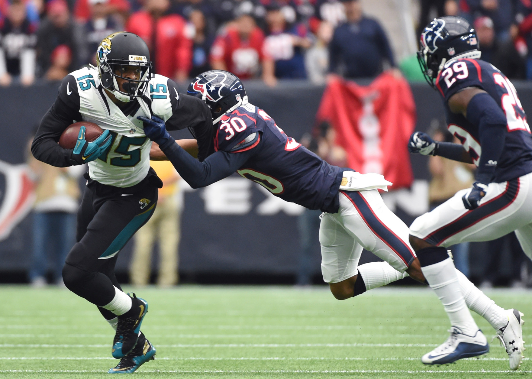 Jacksonville Jaguars wide receiver Allen Robinson (15) tries to break a tackle by Houston Texans strong safety Kevin Johnson (30) during the first half of an NFL football game Sunday, Jan. 3, 2016, in Houston. (AP Photo/Eric Christian Smith)