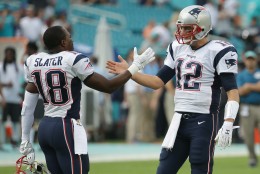 New England Patriots quarterback Tom Brady (12)  greets wide receiver Matthew Slater (18) on the field before an NFL football game against the Miami Dolphins, Sunday, Jan. 3, 2016 in Miami Gardens, Fla. (AP Photo/Lynne Sladky)