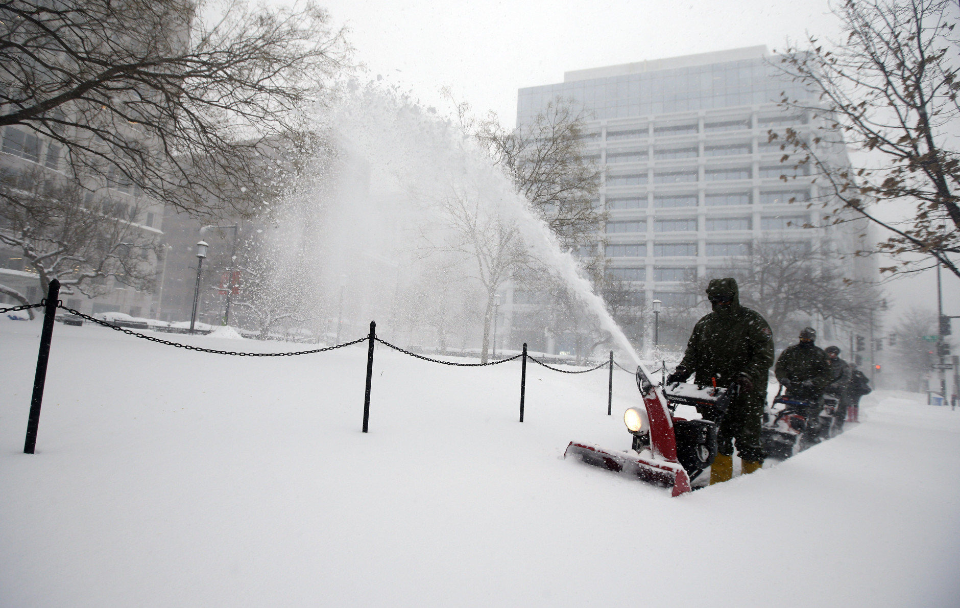 U.S. Park Service employees use snow blowers to clear the sidewalk of Edward R. Murrow park, Saturday, Jan. 23, 2016 in Washington. A blizzard with hurricane-force winds brought much of the East Coast to a standstill Saturday, dumping as much as 3 feet of snow, stranding tens of thousands of travelers and shutting down the nation's capital and its largest city. (AP Photo/Alex Brandon)