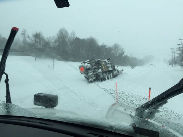 A snow plow has slipped off the road, and tilted sideways, on Saturday, Jan. 23, 2016. Virginia Department of Transportation is warning motorists to stay off the roads as a major winter storm pounds the East Coast. (WTOP/Max Smith)