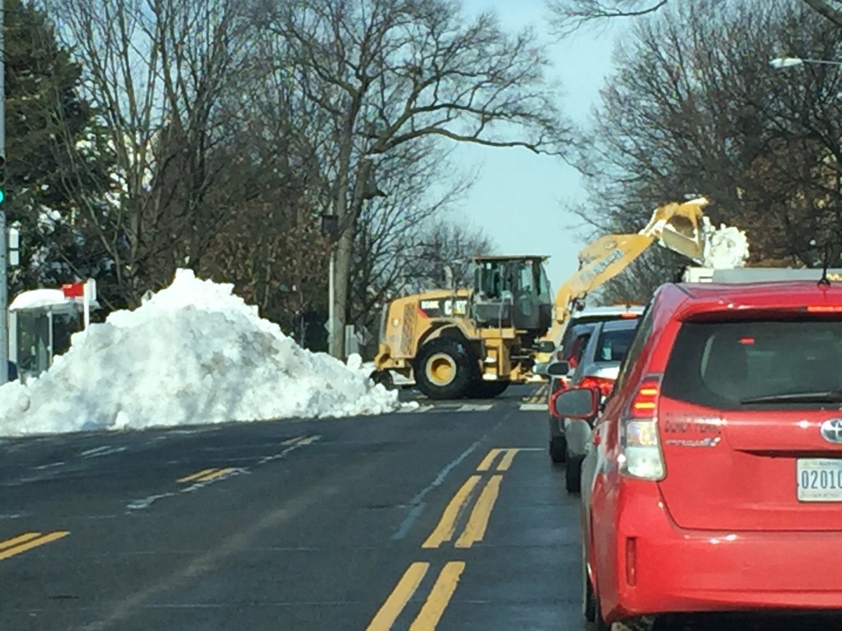 Crews work on a massive pile of snow on Connecticut Avenue in Washington, D.C. (WTOP/Rich Johnson)