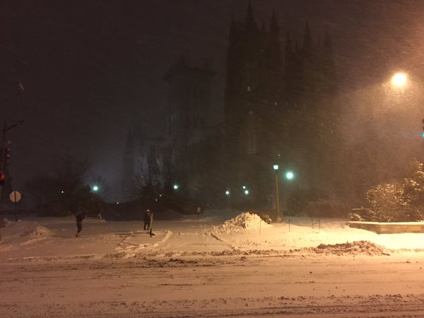 People laugh and playing in the snow outside Washington National Cathedral, along Wisconsin Avenue in Washington, D.C. on Friday, Jan. 22, 2016. (WTOP/Michelle Basch)