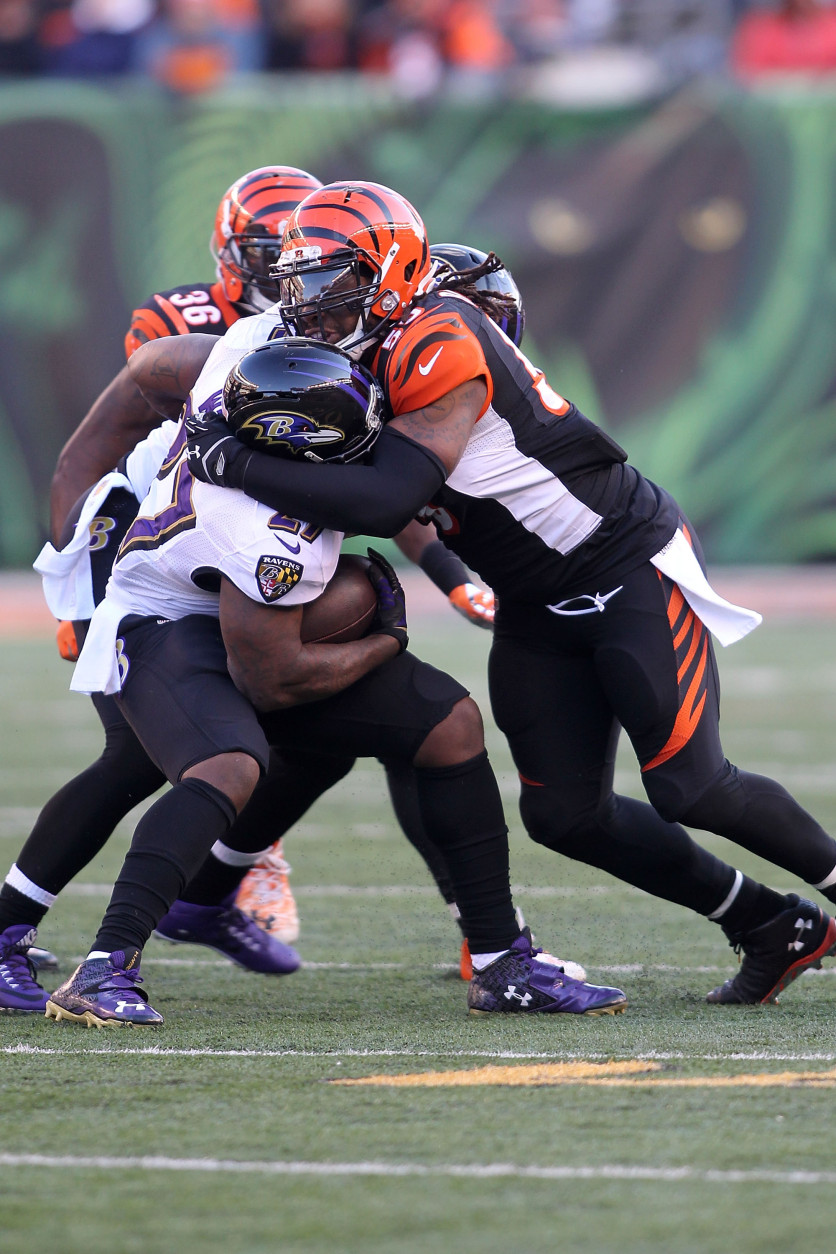 CINCINNATI, OH - JANUARY 3:  Vontaze Burfict #55 of the Cincinnati Bengals tackles Terrance West #27 of the Baltimore Ravens during the third quarter at Paul Brown Stadium on January 3, 2016 in Cincinnati, Ohio. (Photo by John Grieshop/Getty Images)