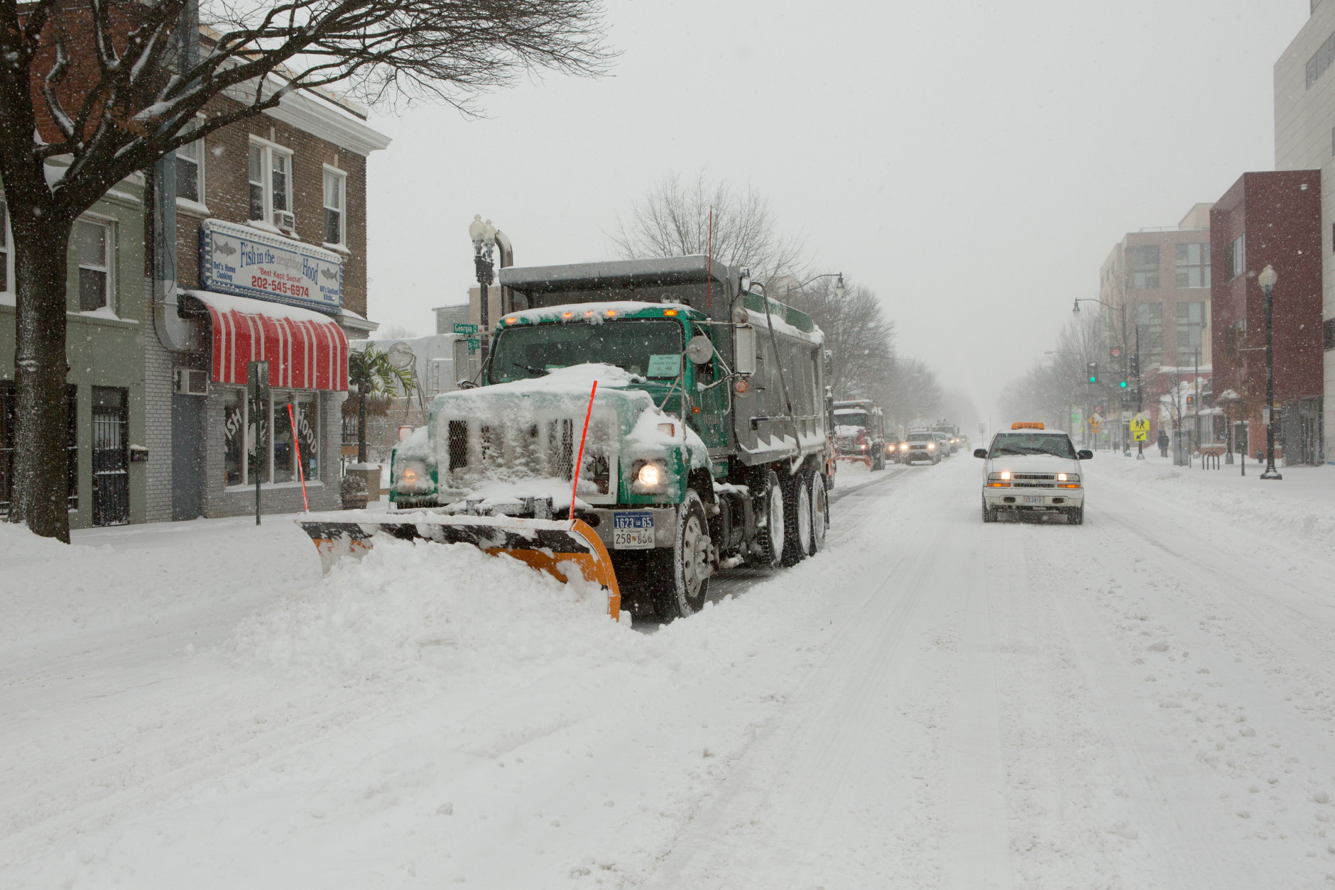 A phalanx of snow plows and city vehicles move north on Georgia Ave. in the Petworth neighborhood on January 23, 2016 in Washington, DC. Over a foot of snow has already fallen in the city in the past 24 hours, in what experts say could be a record-breaking storm. (Photo by Allison Shelley/Getty Images)