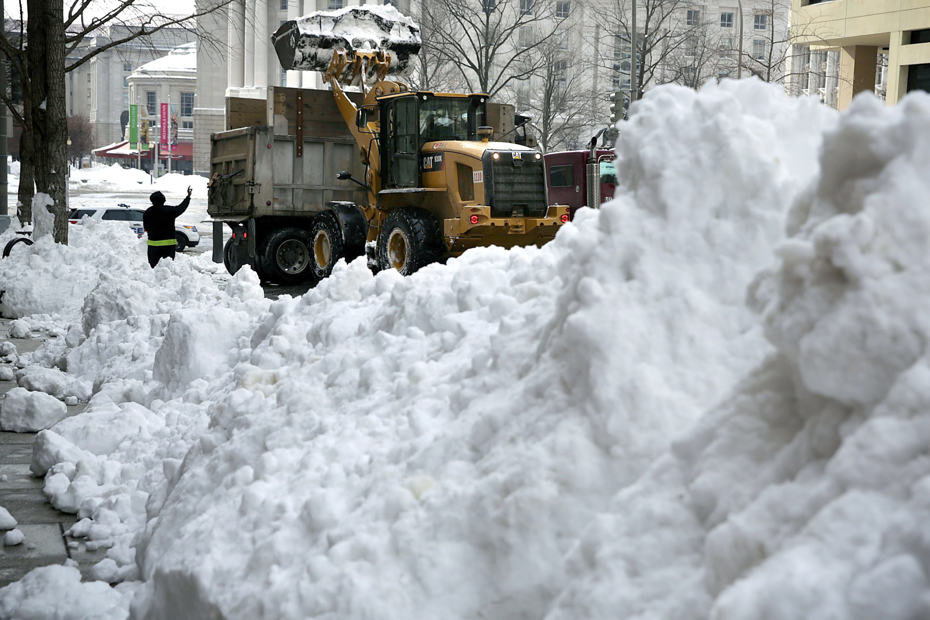 WASHINGTON, DC - JANUARY 25:  A front end loader unloads snow onto a truck on 13th street January 25, 2016 in Washington, DC. Winter Storm Jonas hit the East Coast over the weekend, breaking snowfall records, causing 29 storm-related deaths, leaving thousands of homes without power and serious flooding in coastal areas.   (Photo by Alex Wong/Getty Images)