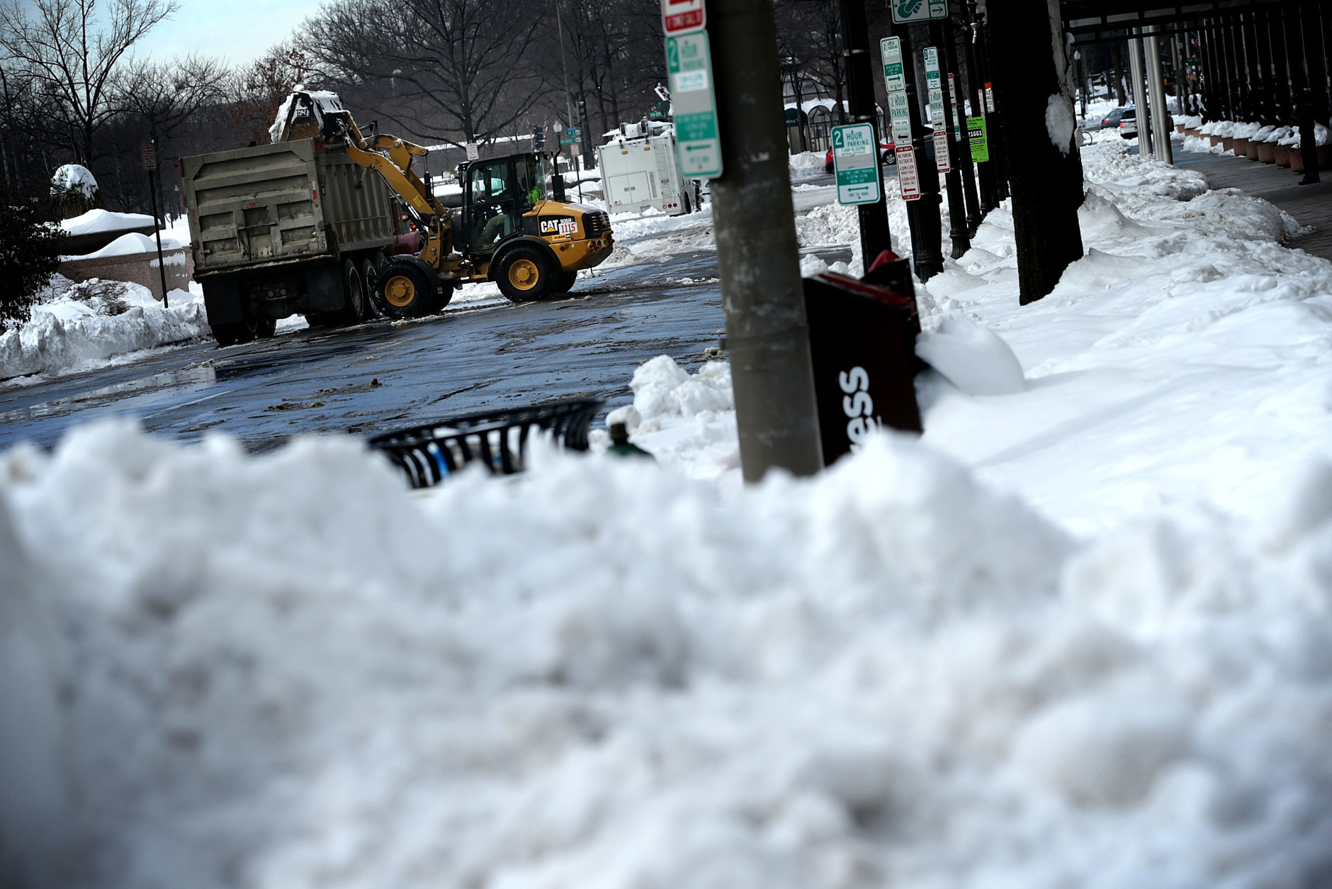 A front end loader unloads snow onto a truck on E street, NW, January 25, 2016 in Washington, DC.  Winter Storm Jonas hit the East Coast over the weekend, breaking snowfall records, causing 29 storm-related deaths, leaving thousands of homes without power and serious flooding in coastal areas.   (Photo by Alex Wong/Getty Images)