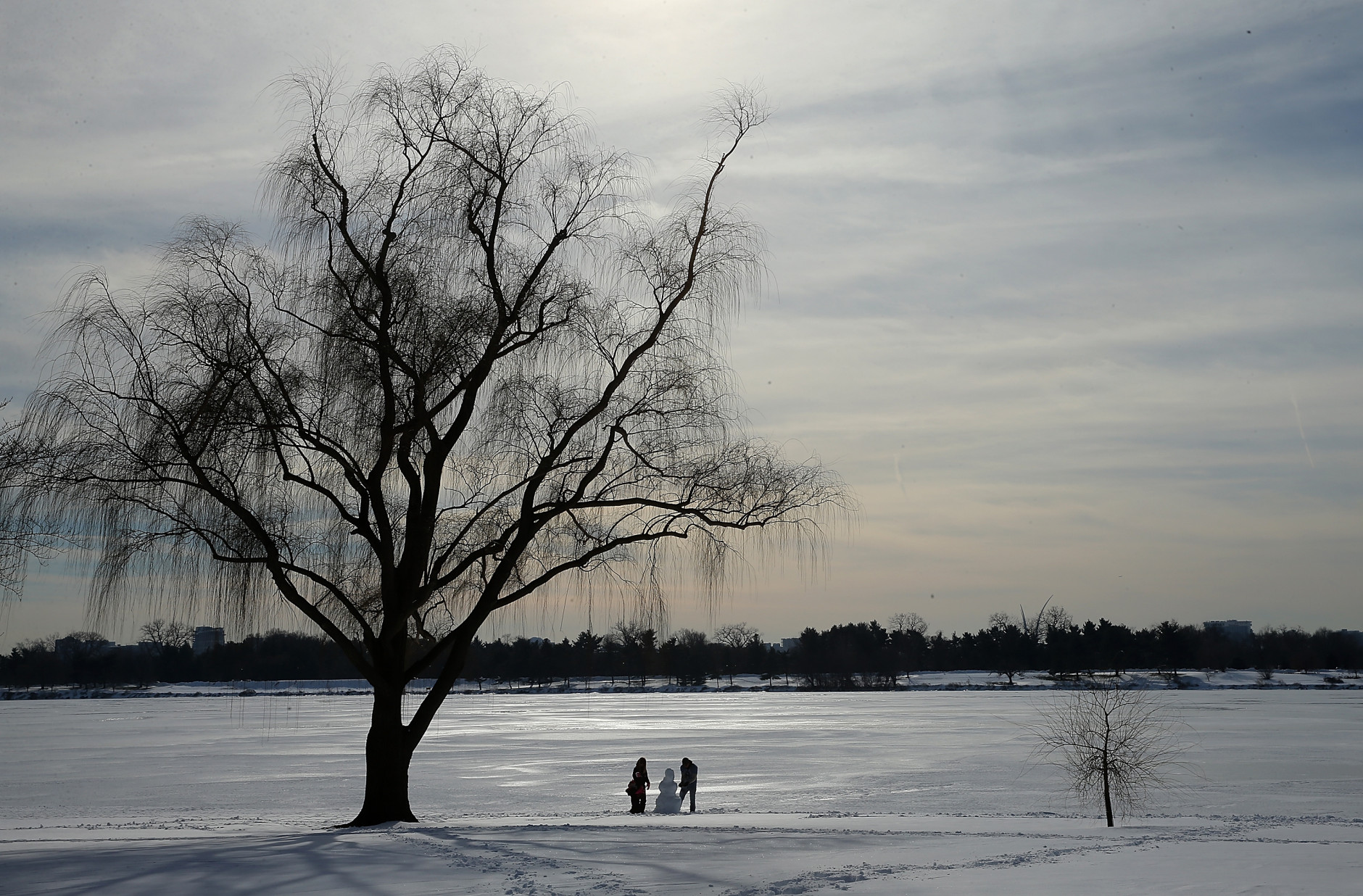 WASHINGTON, DC - JANUARY 25:  A family builds a snowman on the bank of the Potomac River near the Lincoln Memorial January 25, 2016 in Washington, DC. Winter Storm Jonas hit the East Coast over the weekend, breaking snowfall records, closing places of work, causing 29 storm-related deaths, leaving thousands of homes without power and serious flooding in coastal areas.  (Photo by Win McNamee/Getty Images)