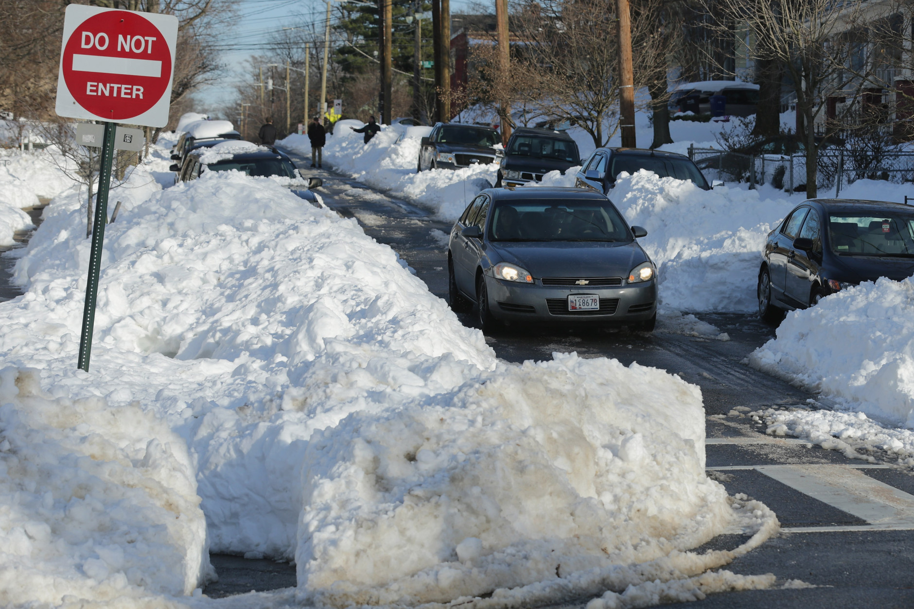 WASHINGTON, DC - JANUARY 25: Vehicle traffic navigates the narrow paths cut through piles of snow in the neighborhood near Catholic Unveristy after Winter Storm Jonas covered the region with more than two feet of snow January 25, 2016 in Washington, United States. The storm hit the East Coast over the weekend, breaking snowfall records, causing 29 storm-related deaths, leaving thousands of homes without power and serious flooding in coastal areas.  (Photo by Chip Somodevilla/Getty Images)