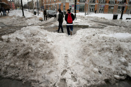 WASHINGTON, DC - JANUARY 26:  Pedestrians traverse piles of snow and slush puddles as they attempt to cross narrowed streets in the Columbia Heights neighborhood following the weekend blizzard January 26, 2016 in Washington, DC. The east coast is still digging out from Winter Storm Jonas that hit the East Coast over the weekend, breaking snowfall records, causing 29 storm-related deaths, and serious flooding in coastal areas.  (Photo by Chip Somodevilla/Getty Images)