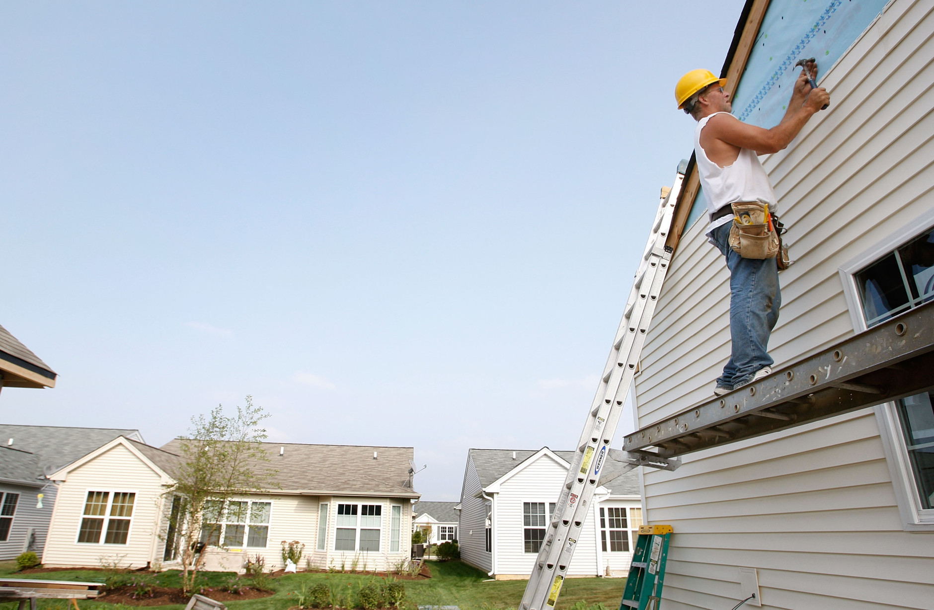 HUNTLEY, IL - AUGUST 19:  John Calendo hangs vinyl siding on a newly-constructed home August 19, 2008 in Huntley, Illinois. According to the U.S. Commerce Department new home construction fell in July with builders breaking ground on 965,000 units, the lowest level in more than 17 years but, still more than the 950,000 units analysts had expected.  (Photo by Scott Olson/Getty Images)