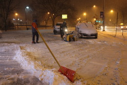 Employees of Tenley Mini Mart in Tenleytown, D.C., worked to clear the parking lot in front of the store on Friday night. (WTOP/Dana Gooley)