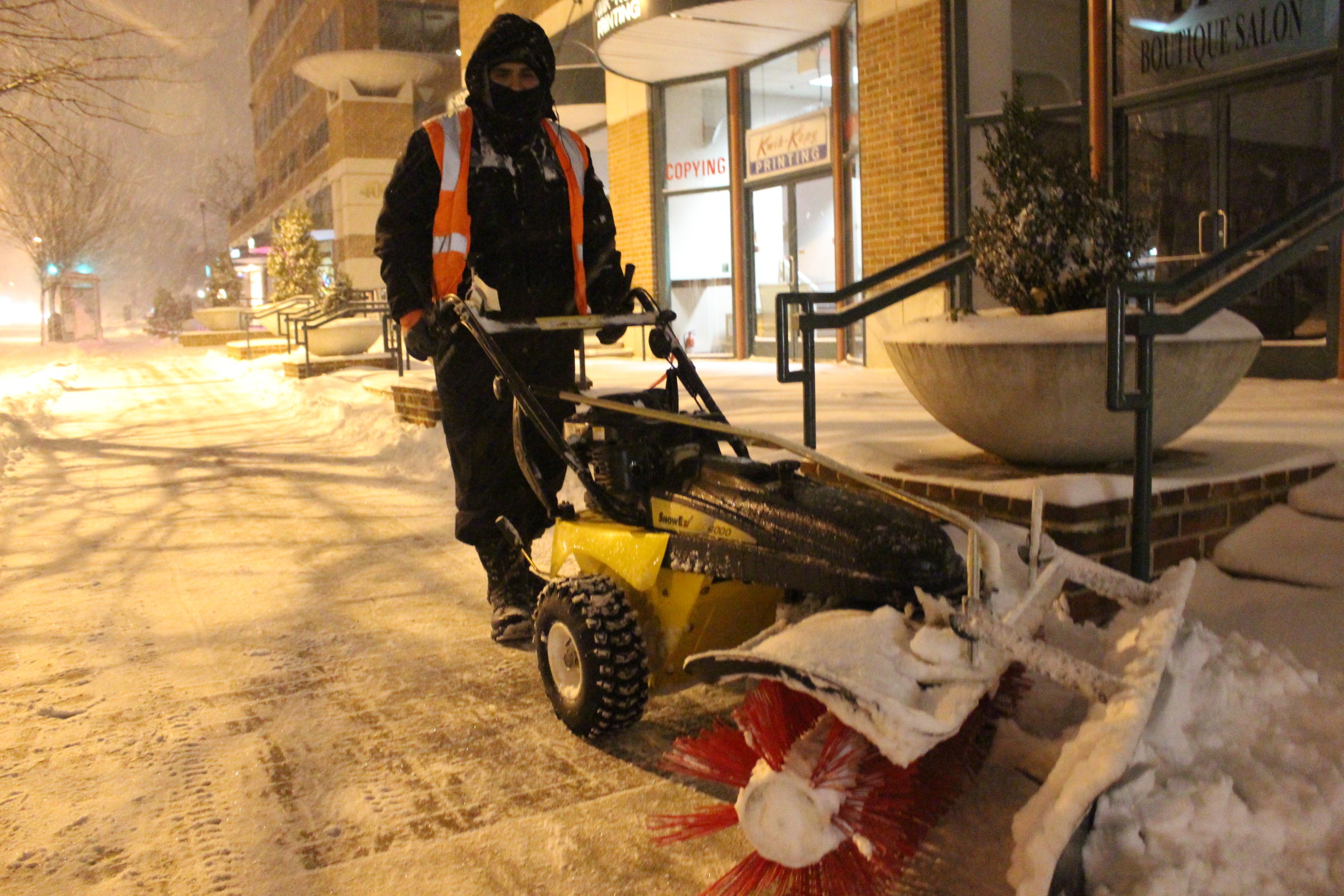 As the snow fell, removal crews worked to clear sidewalks and street corners. (WTOP/Dana Gooley)