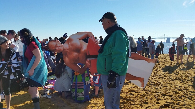 A spectator stands by as thousands of charitable souls brave the chlly waters at the Chesepeake Bay for the Maryland State Police Polar Bear Plunge on Saturday, Jan. 30, 2016. (WTOP/Kathy Stewart)