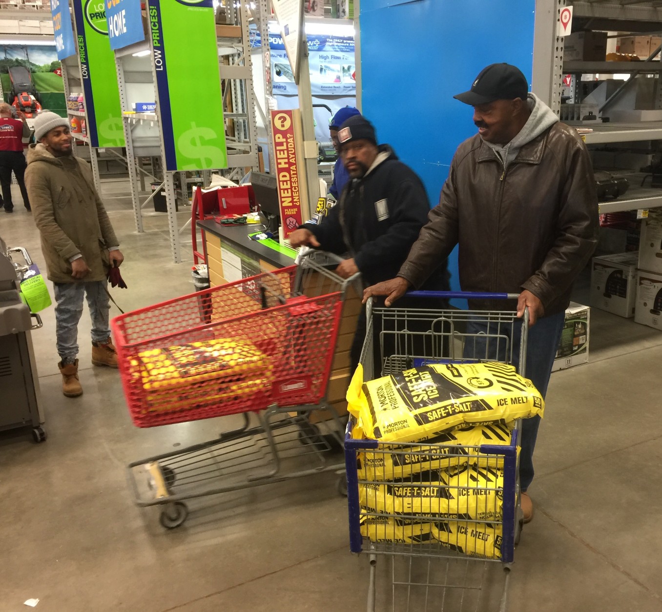 George Currie of Oxon Hill on left, doesn't need the 200 pounds of ice melt in his cart. "I can't say what other people would do. But this is in our [he and his wife’s] hearts to get enough so if someone doesn't have - it's enough for them too." 