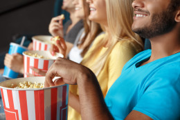 Friends eating popcorn at the movie theatre