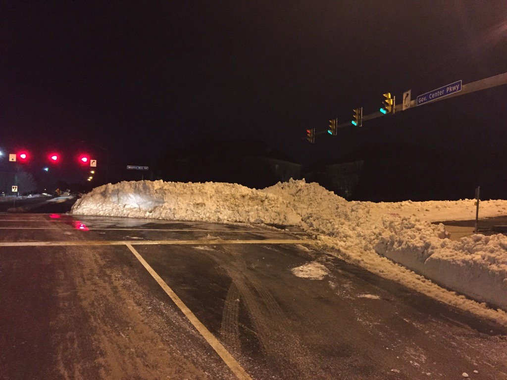 A mound of snow in an intersection and shiny black ice on the road combine to create a difficult and unsafe maneuver onto Waples Mill Road. (WTOP/Dennis Foley)