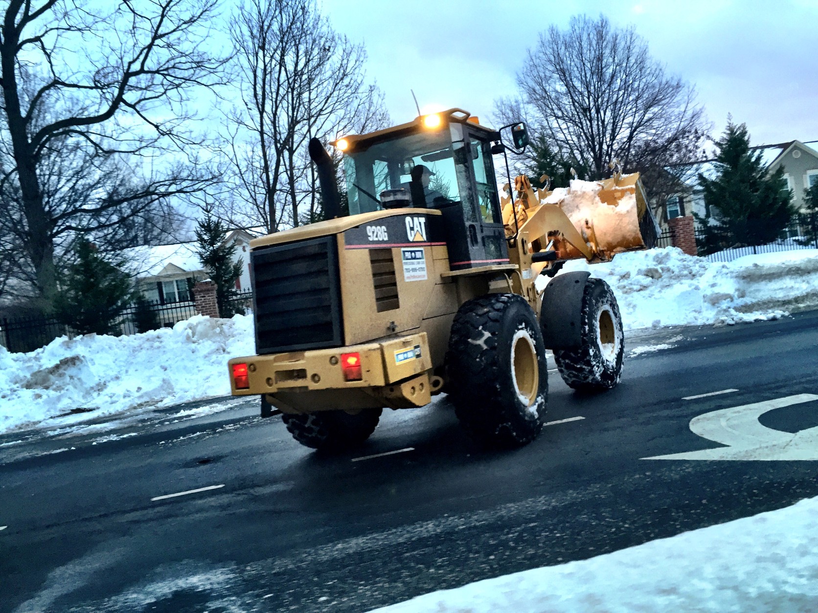 A front end loader removes a lane's worth of snow on West Ox Road. (WTOP/Neal Augenstein)
