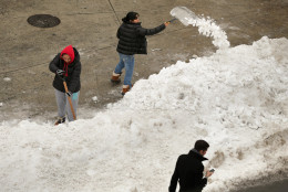 Women attempt to clear a driveway from a wall of plowed snow in the Columbia Heights neighborhood following the weekend blizzard January 26, 2016 in Washington, DC. The east coast is still digging out from Winter Storm Jonas that hit the East Coast over the weekend, breaking snowfall records, causing 29 storm-related deaths, and serious flooding in coastal areas. (Photo by Chip Somodevilla/Getty Images)