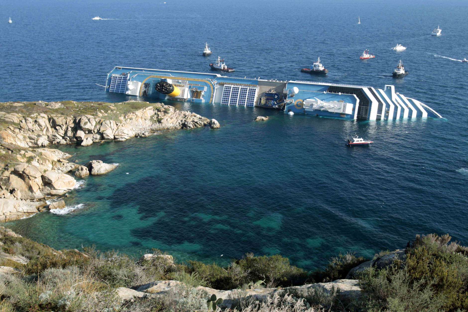 FILE - In this Jan. 14, 2012 file photo the luxury cruise ship Costa Concordia leans on its side after running aground in the tiny Tuscan island of Giglio, Italy. The captain of the shipwrecked Costa Concordia cruise ship Francesco Schettino was convicted Tuesday, May 31, 2016, of multiple charges of manslaughter and sentenced to 16 years in jail, Italian court officials said. (AP Photo/Gregorio Borgia, File)