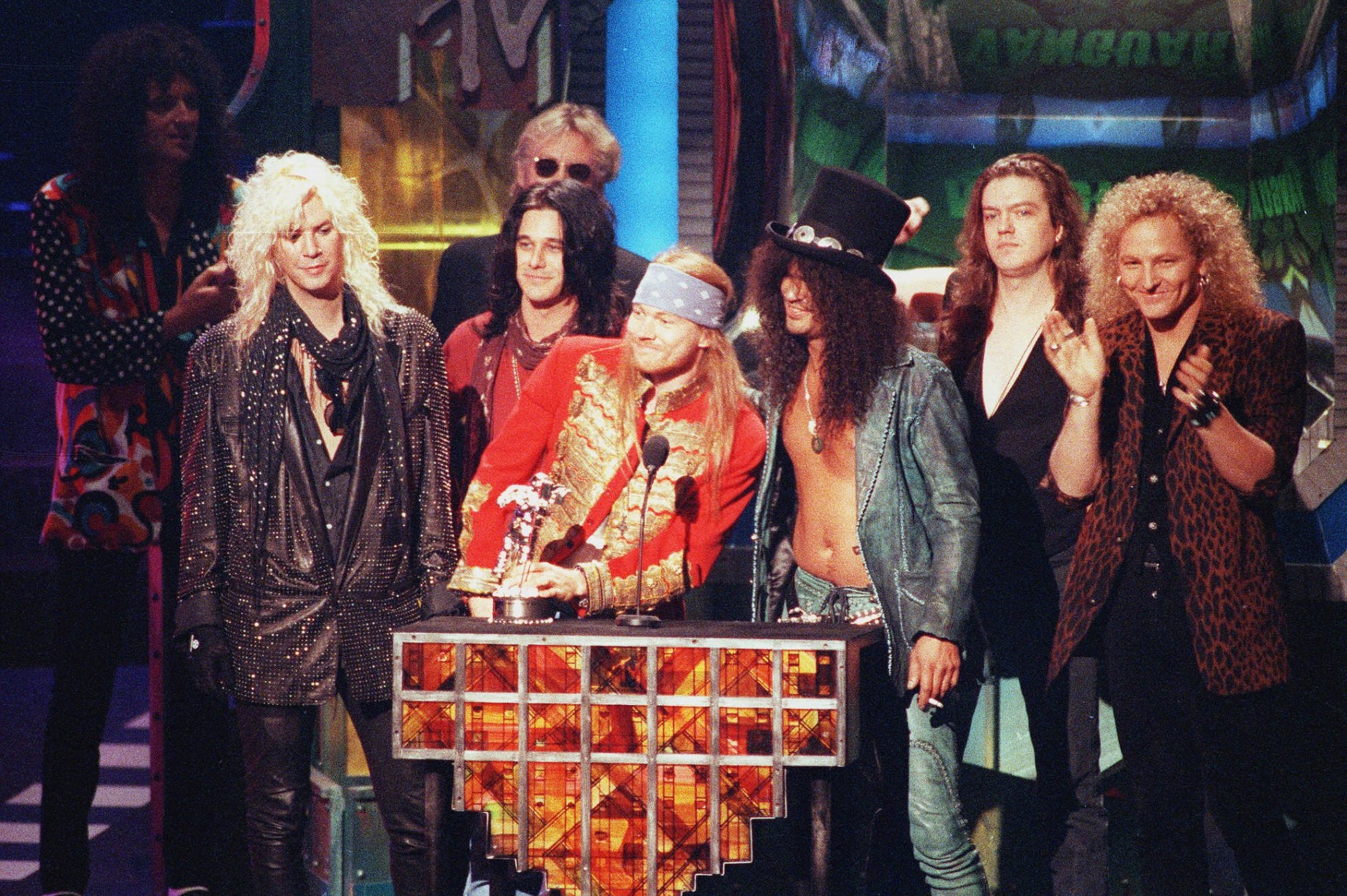 Guns N' Roses celebrate their Michael Jackson Video Vanguard Award for "November Rain" at the MTV Video Music ceremony Sept. 10, 1992 in Los Angeles.  At the podium are Axl Rose, left, Slash.  With them are Duff McKagan, at left with blond hair, and Gilby Clarke, Dizzy Reed, and Matt Sorum.  (AP Photo/Kevork Djansezian)