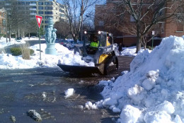A contractor uses a bobcat to clear snow from a D.C. street in McLean Gardens Thursday. (WTOP/Amanda Iacone)