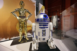 In this photo taken Thursday, Jan. 29, 2015, C-3PO, left, and R2-D2 costumes are displayed as part of an exhibit on the costumes of Star Wars at Seattle’s EMP Museum. The creators of the new exhibit, with 60 original costumes from the six Star Wars movies, are hoping to gather geeks, fashionistas and movie fans together to discuss how clothing helps set the scene. The exhibit, “Rebel, Jedi, Princess, Queen: Star Wars and the Power of Costume,” will be in Seattle through early October and then travel across the United States through 2020. (AP Photo/Elaine Thompson)