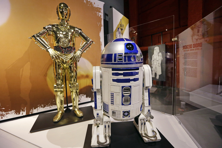 In this photo taken Thursday, Jan. 29, 2015, C-3PO, left, and R2-D2 costumes are displayed as part of an exhibit on the costumes of Star Wars at Seattle’s EMP Museum. The creators of the new exhibit, with 60 original costumes from the six Star Wars movies, are hoping to gather geeks, fashionistas and movie fans together to discuss how clothing helps set the scene. The exhibit, “Rebel, Jedi, Princess, Queen: Star Wars and the Power of Costume,” will be in Seattle through early October and then travel across the United States through 2020. (AP Photo/Elaine Thompson)