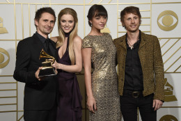 Matt Bellamy, left, and Dominic Howard, right of Muse pose in the press room with the award for best rock album for "Drones" along with Elle Evans, second left and Rayana Ragan, second right at the 58th annual Grammy Awards at the Staples Center on Monday, Feb. 15, 2016, in Los Angeles. (Photo by Chris Pizzello/Invision/AP)
