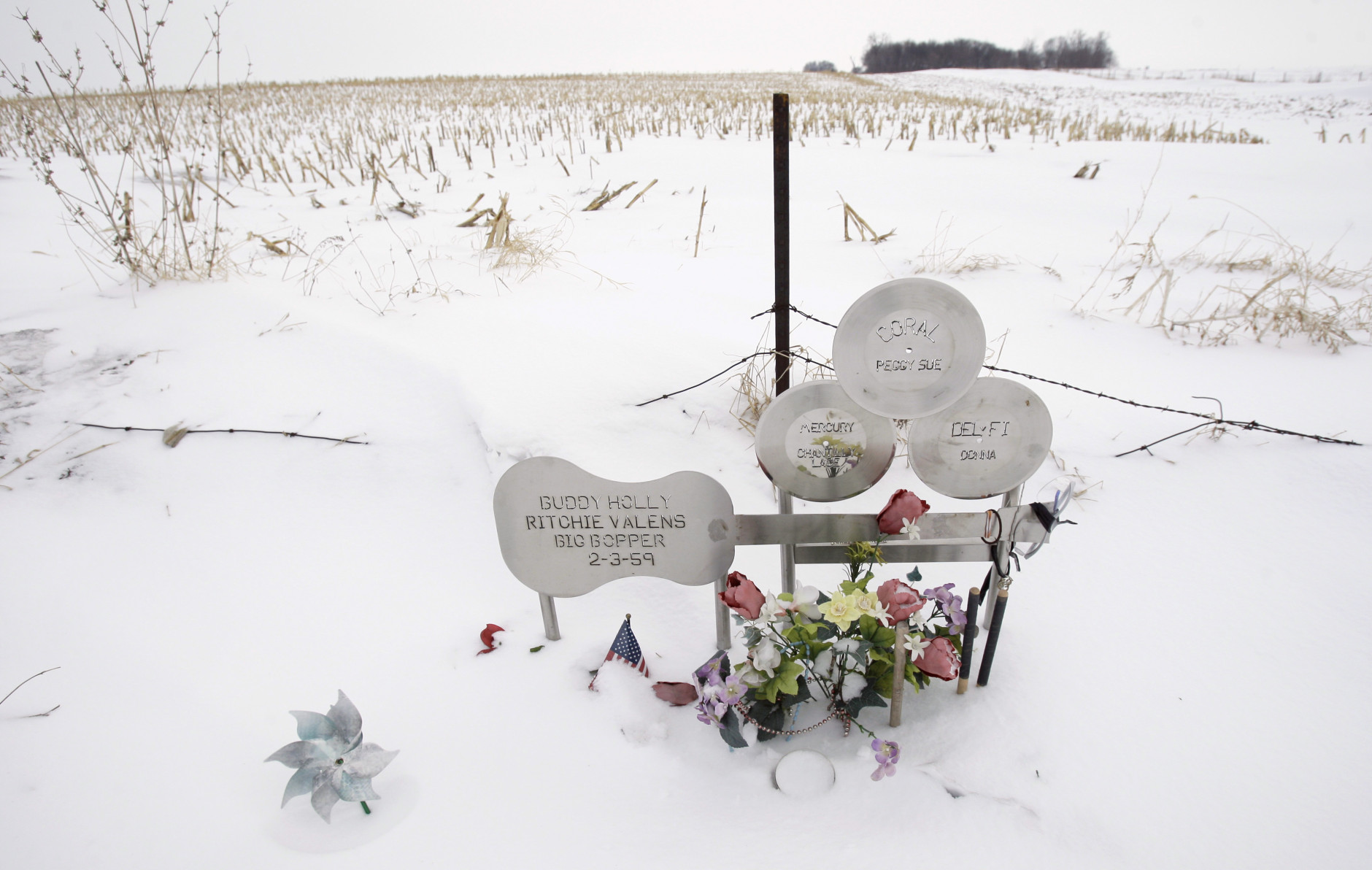 FILE - In this Friday, Jan. 9, 2009 file photo, flowers adorn a memorial at the spot where the plane carrying Buddy Holly, Ritchie Valens and J.P. "The Big Bopper" Richardson crashed killing all aboard on Feb. 3, 1959, near Clear Lake, Iowa. The three young singers were in a single-engine aircraft flying in a light snowstorm in 1959 when the pilot apparently lost control. Holly decided to fly because his tour bus was having heating problems. (AP Photo/Charlie Neibergall, File)