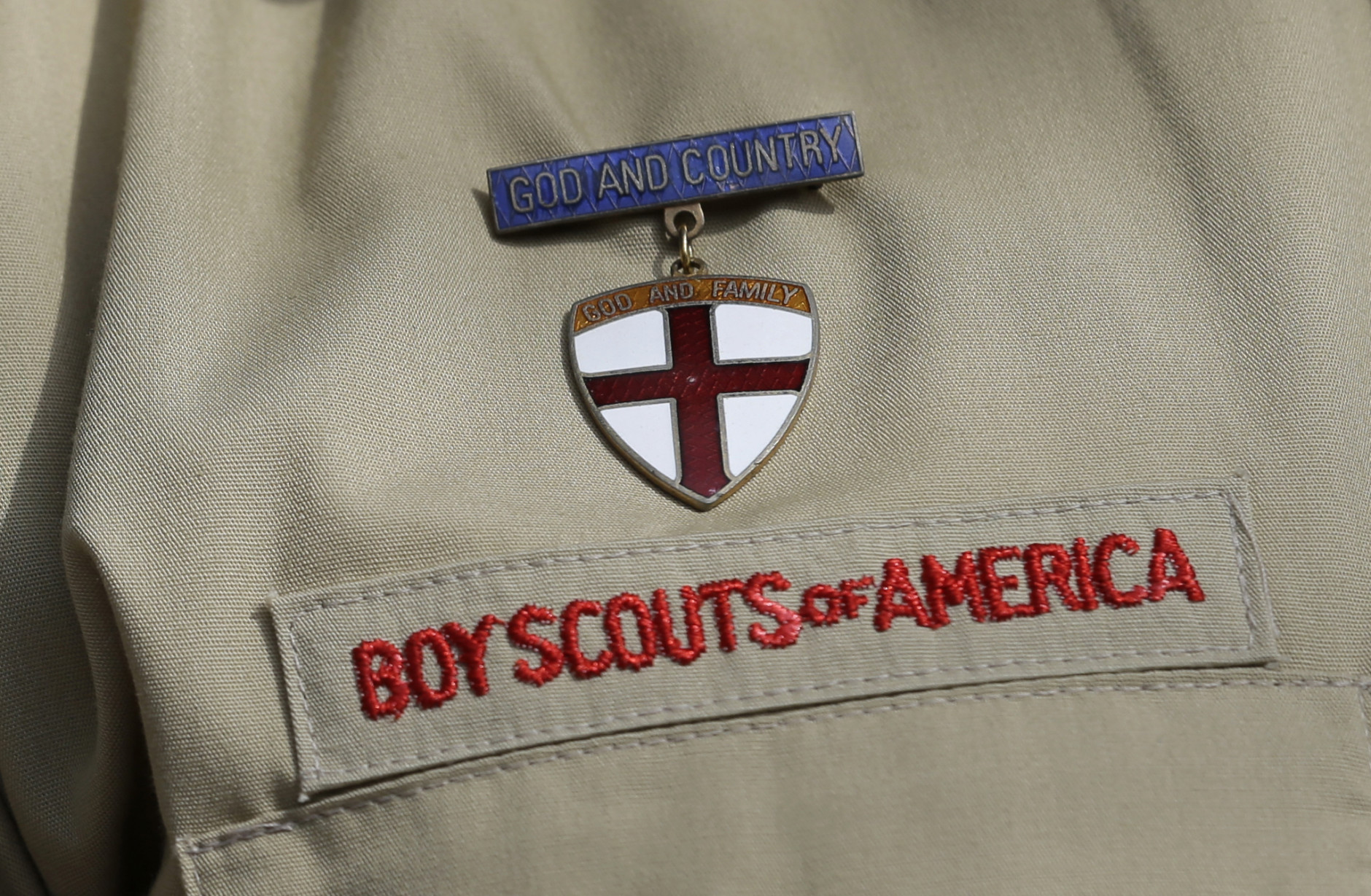 File - In this Feb. 4, 2013 file photo, shows a close up detail of a Boy Scout uniform worn during a news conference in front of the Boy Scouts of America headquarters in Irving, Texas. Attorneys for the Boy Scouts of America have reached a settlement with a former San Antonio Scout who says he was abused by his adult leader. (AP Photo/Tony Gutierrez, File)