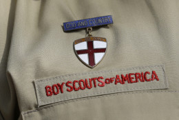 File - In this Feb. 4, 2013 file photo, shows a close up detail of a Boy Scout uniform worn during a news conference in front of the Boy Scouts of America headquarters in Irving, Texas. Attorneys for the Boy Scouts of America have reached a settlement with a former San Antonio Scout who says he was abused by his adult leader. (AP Photo/Tony Gutierrez, File)