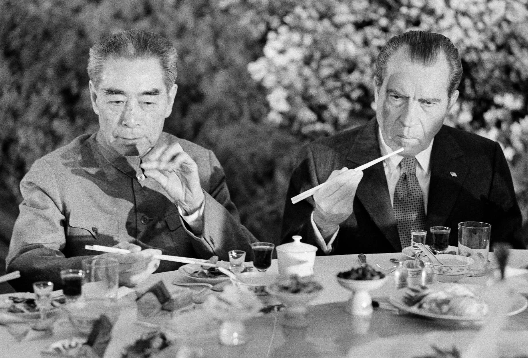 U.S. President Richard Nixon, right, is serious-faced as he eats with chopsticks in Shanghai, China, on Sunday, February 28, 1972.   At left is China's Premier Chou En-lai.     (AP Photo)