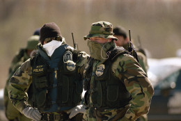 Two Alcohol, Tobacco and Firearms agents cover their faces to guard against the cold as a major cold front moved through central Texas on Saturday, March 13, 1993. They are guarding the Branch Davidian compound as the standoff with the religious cult enters its 14th day. (AP Photo/David Longstreath)