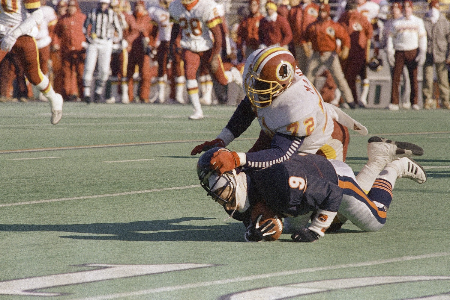 Bears quarterback Jim McMahon (9) is sacked by Redskins Dexter Manley during first quarter action in Chicago on Sunday, Jan. 10, 1988. (AP Photo/Mark Elias)