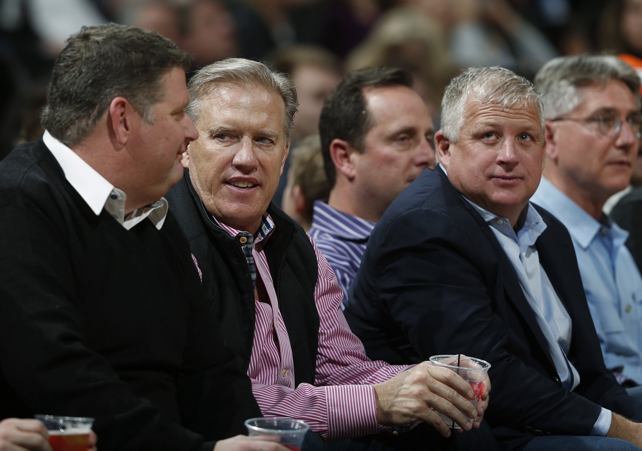 Denver Broncos executive vice president of football operations John Elway, second from left, sits in court side seat to watch the Denver Nuggets host the Detroit Pistons in the first half of an NBA basketball game Saturday, Jan. 23, 2016, in Denver. (AP Photo/David Zalubowski)