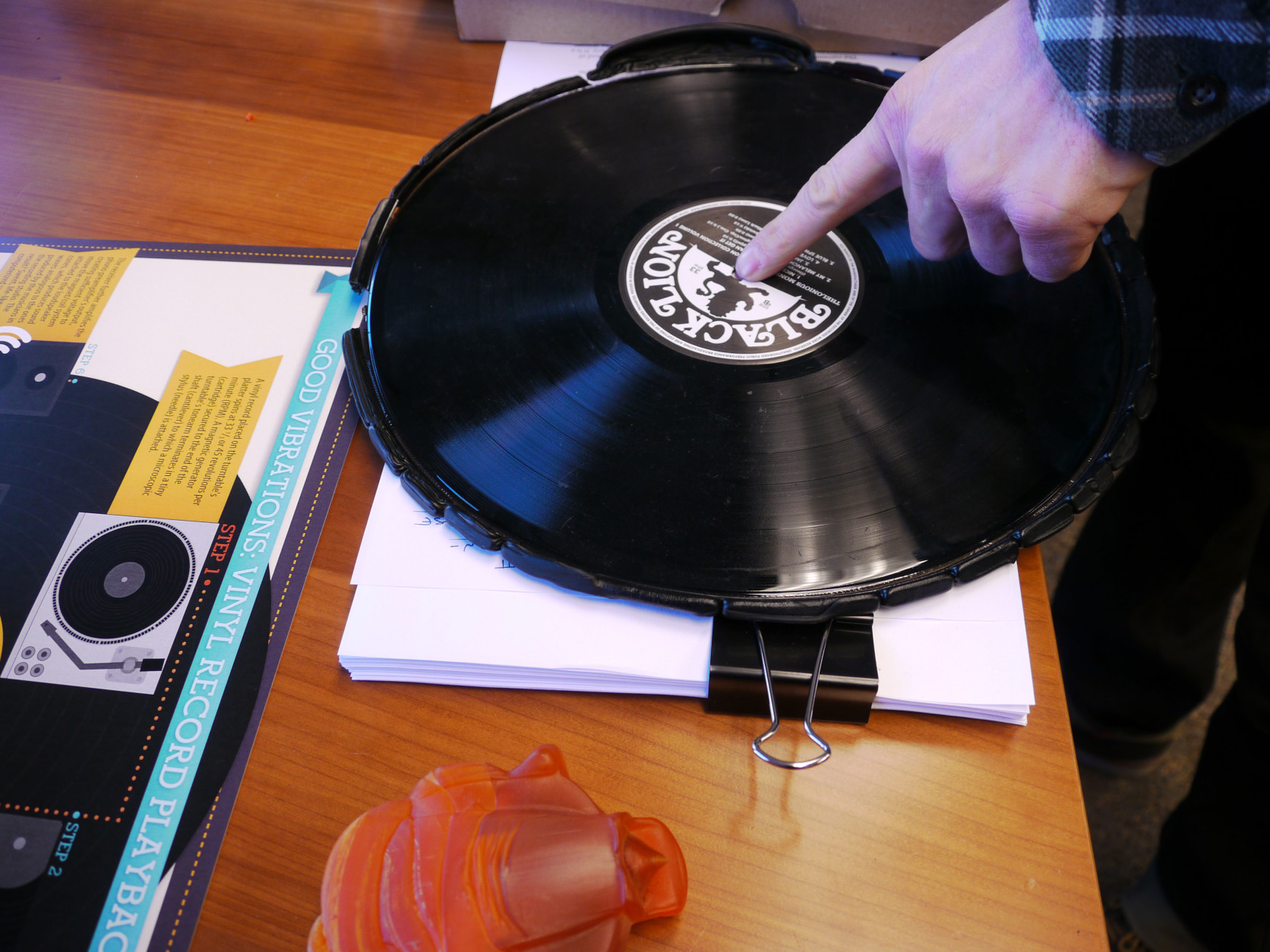 During the record-making process, a knife will cut away the excess vinyl from a pressing. Eric Astor, president and founder of Furnace Record Pressing in Fairfax, Va.shows a sample of a record that has not been cut. (WTOP/Tiffany Arnold)