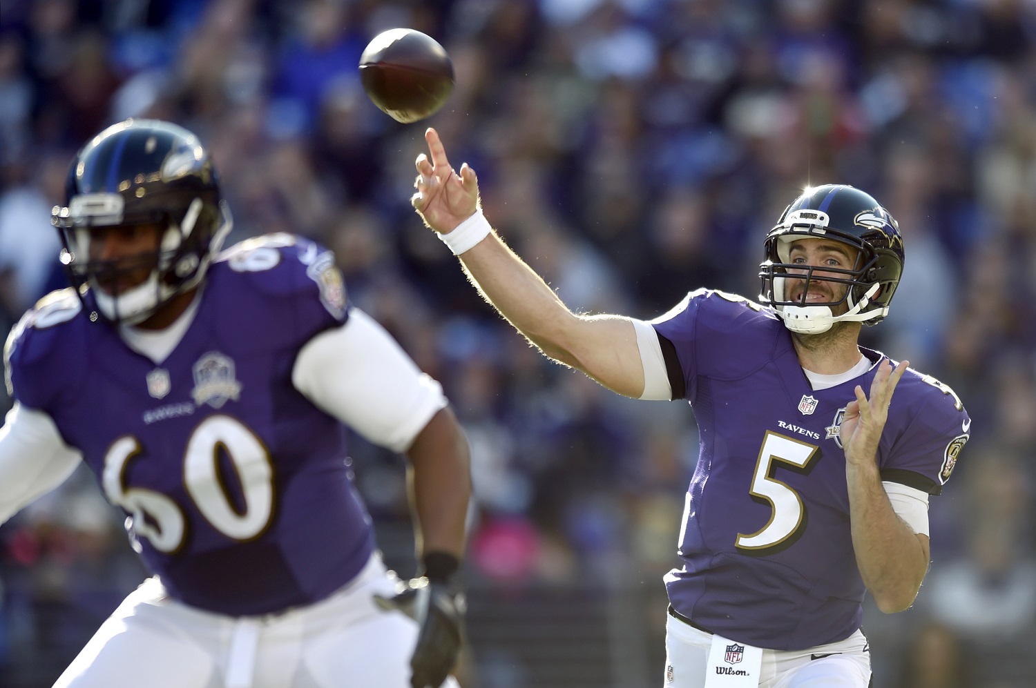 Baltimore Ravens quarterback Joe Flacco (5) throws to a receiver as he is protected by tackle Eugene Monroe in the first half an NFL football game against the Jacksonville Jaguars, Sunday, Nov. 15, 2015, in Baltimore. (AP Photo/Gail Burton)