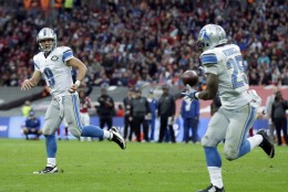 Detroit Lions quarterback Matthew Stafford (9) throws a touchdown pass to running back Theo Riddick (25) in the second half of the NFL football game against the Atlanta Falcons at Wembley Stadium, London, Sunday, Oct. 26, 2014.  (AP Photo/Matt Dunham)