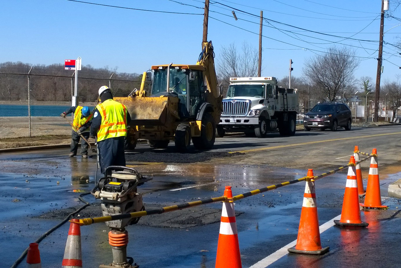 Crews repair MacArthur Boulevard Thursday morning after a water main break damaged the road. (WTOP/Megan Matthews)