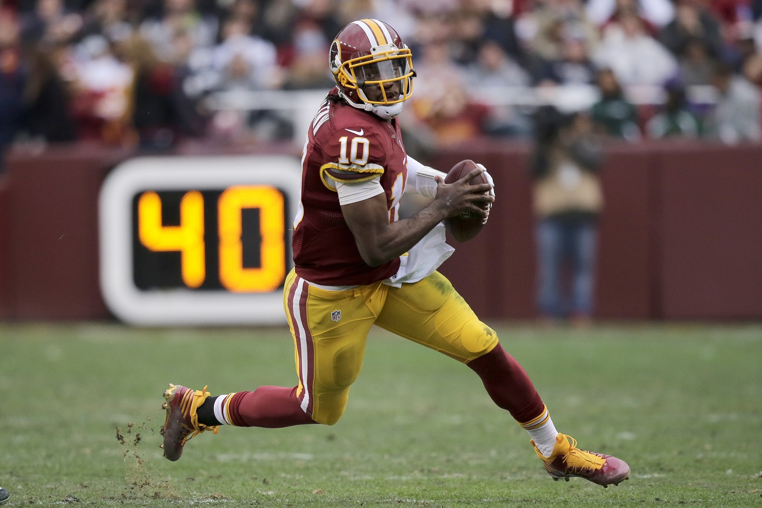 Washington Redskins quarterback Robert Griffin III (10) scrambles with the ball during the first half of an NFL football game against the Dallas Cowboys in Landover, Md., Sunday, Dec. 28, 2014. (AP Photo/Mark Tenally)
