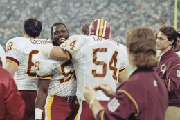 Washington Redskins' Wilber Marshall is hugged by teammate Kurt Gouveia on the Washington bench as they celebrate the Redskins 37-24 victory over the Buffalo Bills in Super Bowl XXVI, Jan. 26, 1992 in Minneapolis. (AP Photo/Greg Gibson)